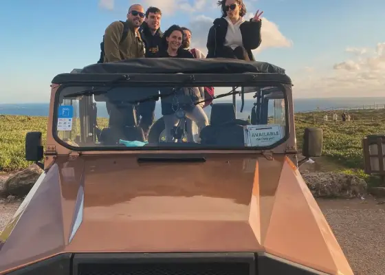 Guests with a classic YourTuk jeep by the Atlantic