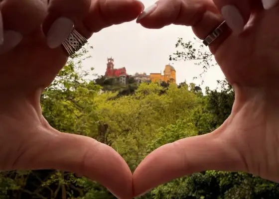 Pena Palace framed by a heart made with hands