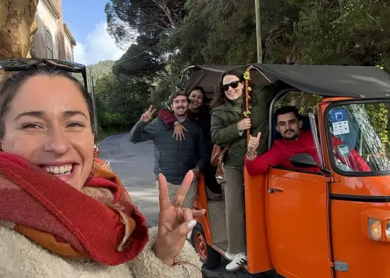 A YourTuk guide and guests beside an orange tuk-tuk